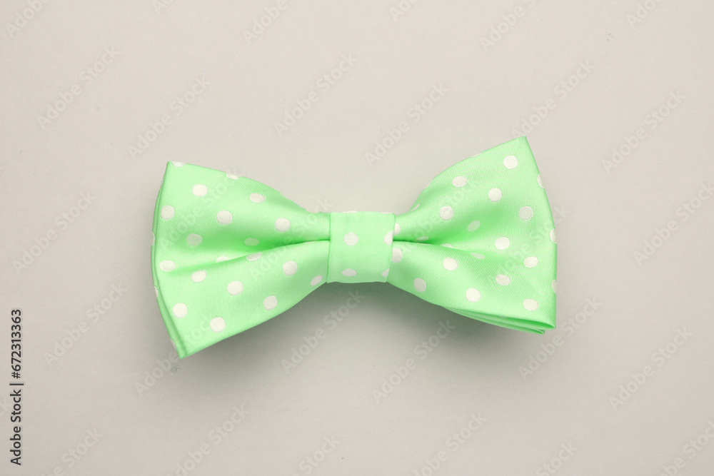 Stylish spring green bow tie with polka dot pattern on light grey background, top view Stylish spring green bow tie with polka dot pattern on light grey background, top view
