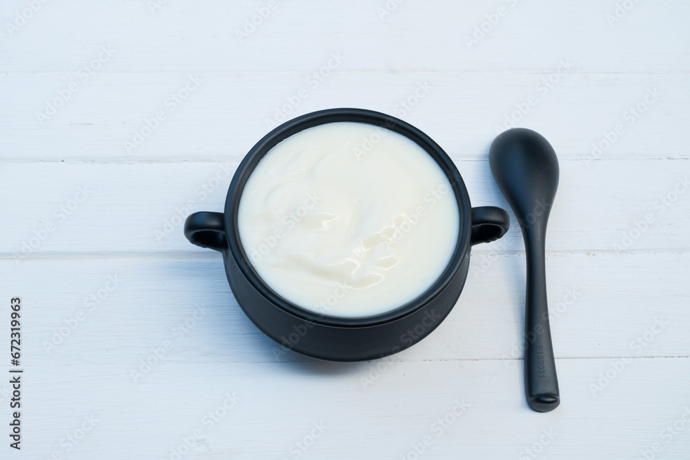 Yogurt greek white clean In bowl with spoon on a wooden background from top view.
Yogurt greek white clean In bowl with spoon on a wooden background from top view.