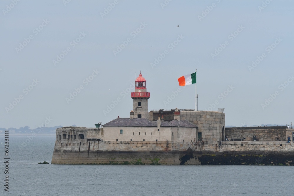 Lighthouse on the East Pier in Dun Laoghaire, Dublin, Ireland with the flag of the Irish Republic. Lighthouse on the East Pier in Dun Laoghaire, Dublin, Ireland with the flag of the Irish Republic.