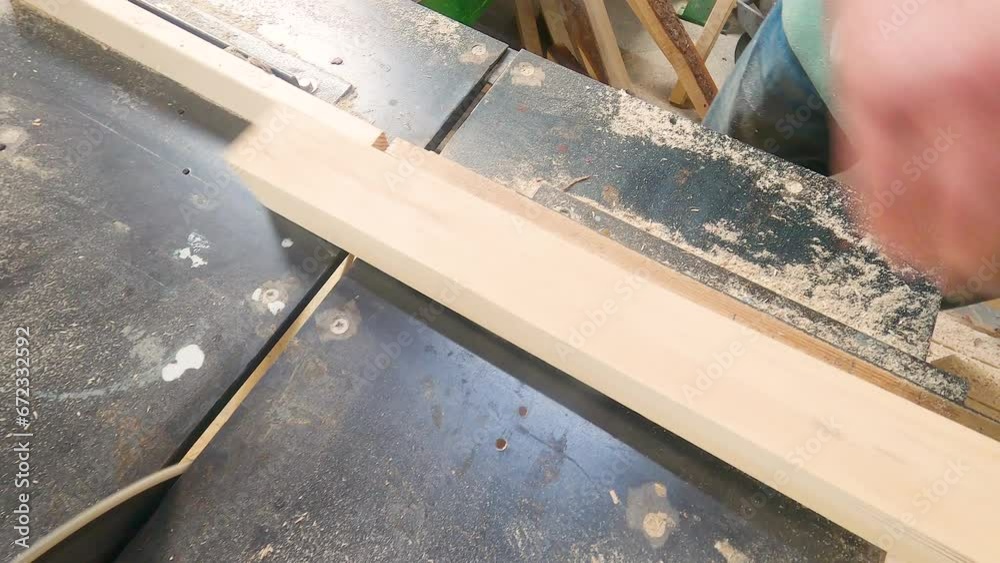 Carpenter cuts wooden board on a circular saw in a carpentry workshop Carpenter cuts wooden board on a circular saw in a carpentry workshop