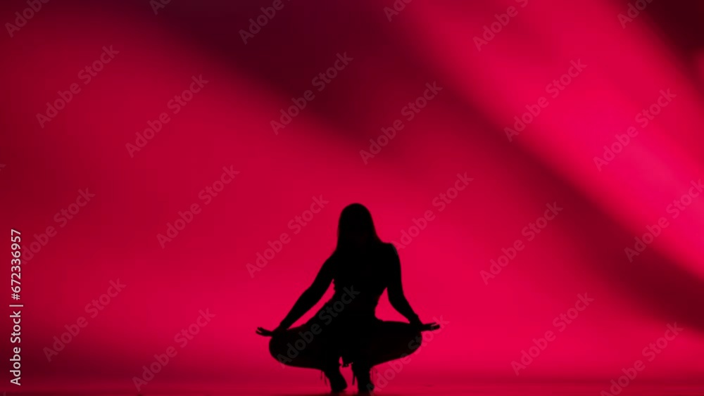 Woman silhouette dancing heels dance in a studio. Bright red neon light, shadowed background. Black sexy costume, high heels. Modern sensual choreography. Full length.