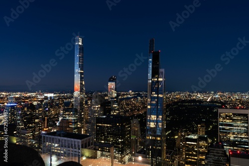 Aerial view of a Rockefeller Center in New York lit up at nightw with illuminated skyscrapers