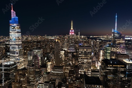 Aerial view of a Rockefeller Center in New York lit up at nightw with illuminated skyscrapers