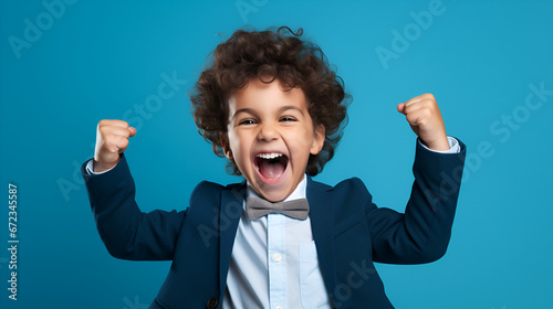 Little CEO in Action: Exuberant Celebration of Success with Cheerful Screams and Fist Pumps on an Isolated Blue Background - High-Quality Stock Photography photo