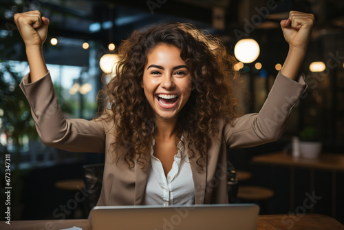 Ecstatic woman celebrating with laptop at night