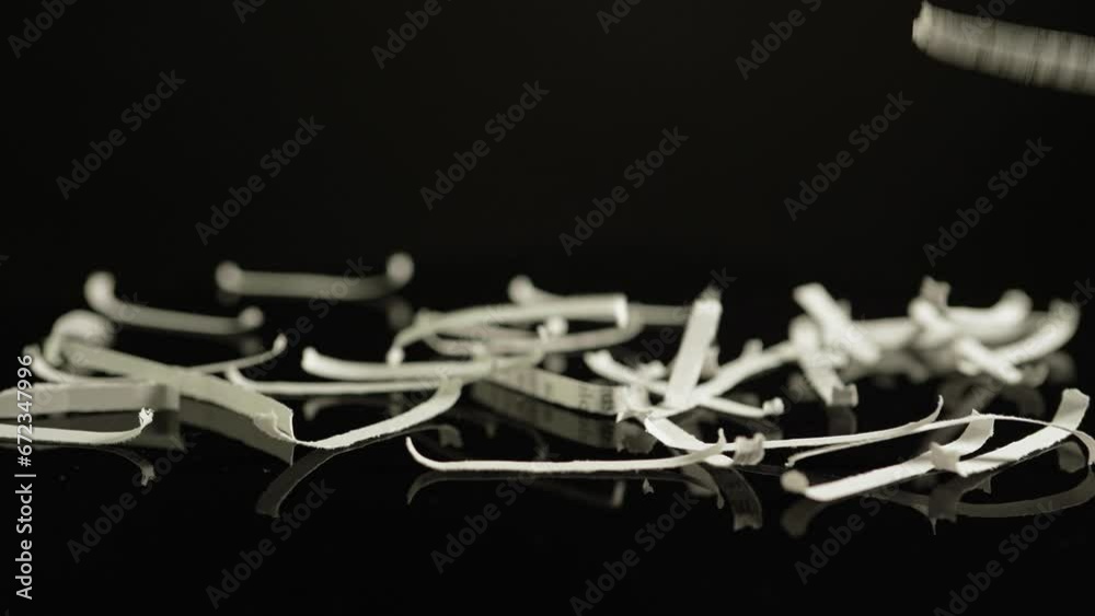 Shredding confidential documents with lorem ipsum text, maintaining data security and privacy. Businesses, government agencies, or personal disposal of sensitive information through shredding.
