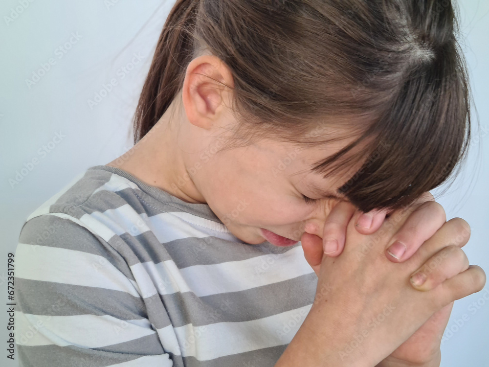 Fototapeta premium Beautiful little girl closed her eyes and prays