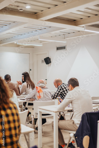 Group of businesspeople gathered in a seminar meeting in a white classroom