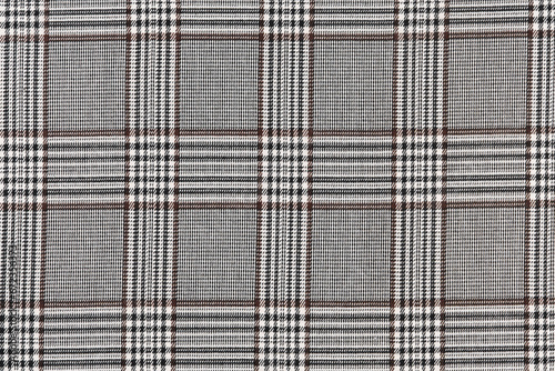 Close-up of the texture of the fabric of black with brown tartan in a check. Material for sewing skirts, shirts, dresses. Traditional Scottish clothing. Background for your design.