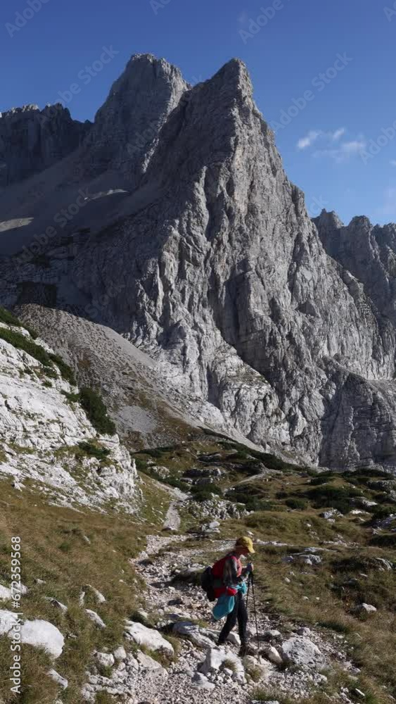 Descending from a Hiking Journey in High Mountains - Backpacker Adult Woman in Julian Alps Slovenia Descending from a Hiking Journey in High Mountains - Backpacker Adult Woman in Julian Alps Slovenia