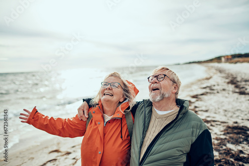Senior couple standing on the beach photo