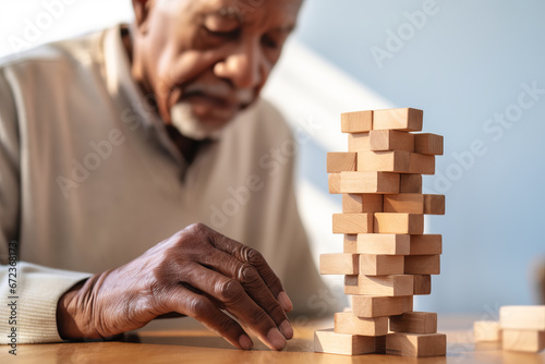 African American Senior man with dementia playing with wooden blocks in geriatric clinic or nursing home