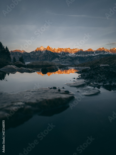 A mountain range with a body of water in the foreground