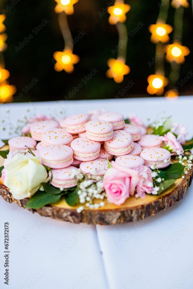 Wooden table with a variety of delicious pink-colored cookies on top of its surface