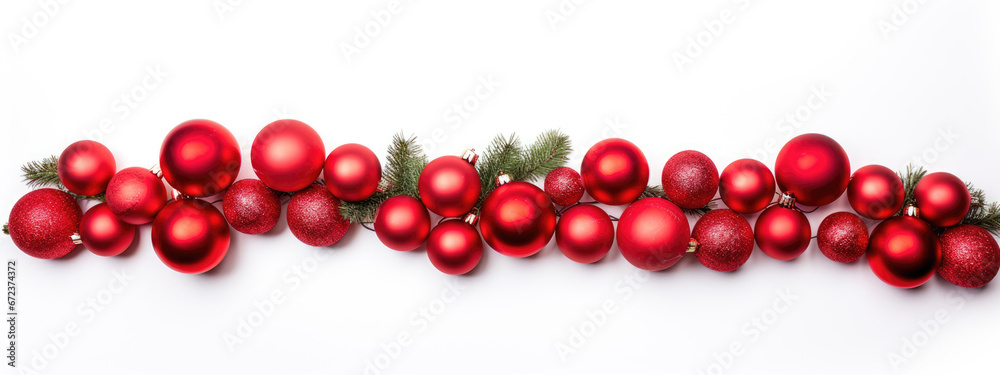 A horizontal line of red Christmas ornaments are neatly arranged on a pine branch against a pure white background. A horizontal line of red Christmas ornaments are neatly arranged on a pine branch against a pure white background.