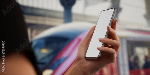 CU view of Caucasain female using her phone on a train station platform photo