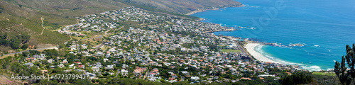 Panoramic landscape of a large city on the coast from above. Beautiful scenic and aerial view of a popular tourist town or residential area with greenery and the ocean in nature during summer