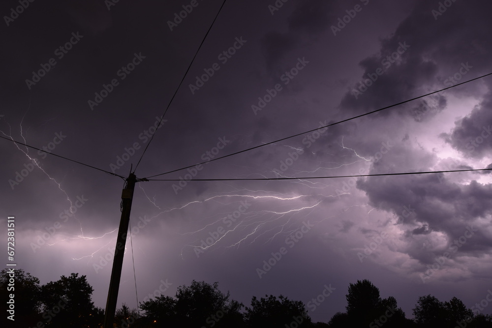 Electric pole with Thunderstorm Overhead. NIght photography of thunder with lightnings.