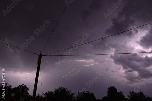 Electric pole with Thunderstorm Overhead. NIght photography of thunder with lightnings.