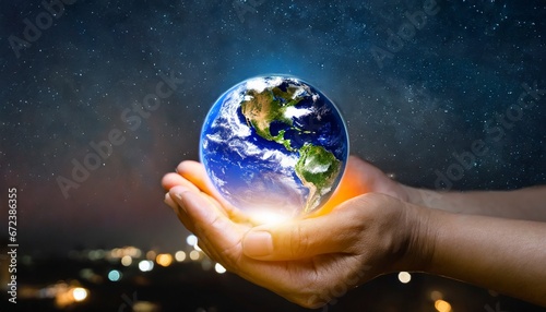 Earth at night was holding in human hands. Earth day. Energy saving concept