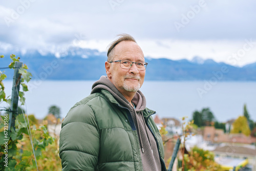Outdoor portrait of middle age 55 - 60 year old man enjoing nice autumn day in vineyards, healthy and active lifestyle