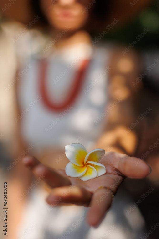 young girl holds a white flower in her palm. A model poses with a flower in her clothes. young girl holds a white flower in her palm. A model poses with a flower in her clothes.