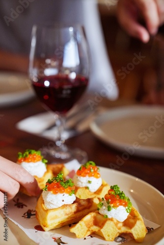 Delicious appetizers: fluffy waffles paired with cheese, topped with fish roe and chives