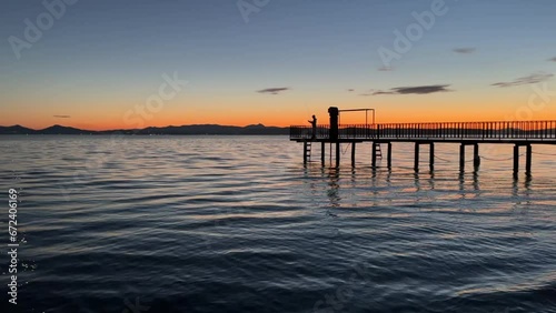 Wallpaper Mural silhouette of the fisherman on the pier at sunset in the calm sea Torontodigital.ca