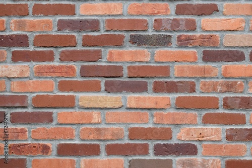 Weathered brick wall with a textured surface and cracks visible on the surface.