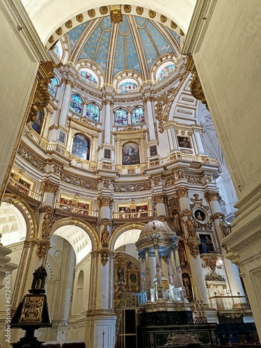 A main altar and the Easter Candle as viewed from the side aisle of the Granada Cathedral  Spain