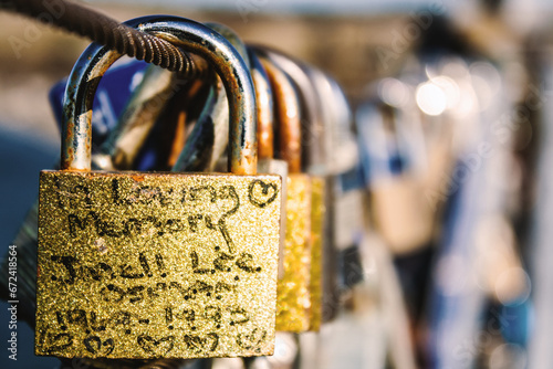 Close-up shot of a collection of three padlocks with a love message inscribed on one of them