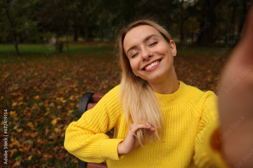 Portrait of happy woman taking selfie in autumn park Portrait of happy woman taking selfie in autumn park