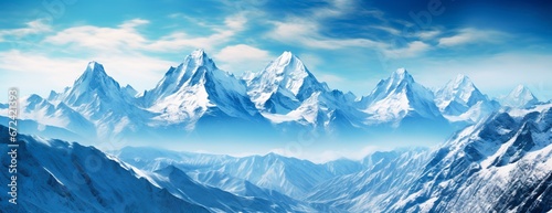 Panoramic view of rocky snowy peaks under blue sky