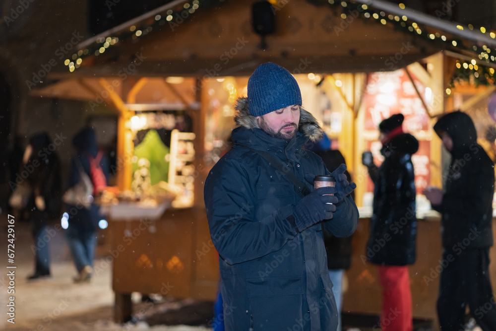 Christmas time, a man drinks hot wine in the Old Town of Tallinn at the Christmas market.