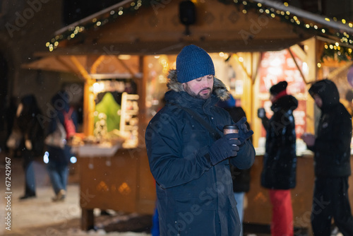 Christmas time, a man drinks hot wine in the Old Town of Tallinn at the Christmas market.