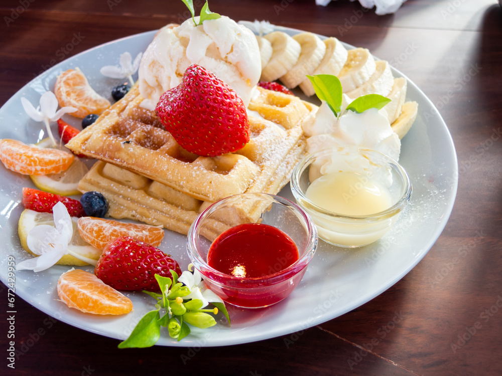 waffle with ice cream and fruits on wood table, top view waffle with ice cream and fruits on wood table, top view