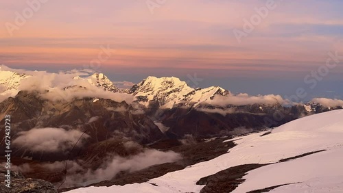 Beautiful Sunset time view time lapse video from Mera peak High Camp at cca 5750m with running foggy clouds with small Kangchenjunga third-highest mountain in the world 8586 m on horizon. photo