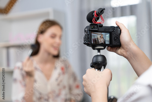 Woman influencer shoot live streaming vlog video review makeup utmost social media or blog. Happy young girl with cosmetics studio lighting for marketing recording session broadcasting online.