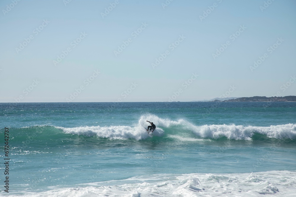 Surfer riding a surfboard on a large set of waves in an ocean