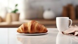 a delectable croissant and a cup of coffee elegantly placed on a kitchen countertop, the scene against a minimalist interior with modern furniture