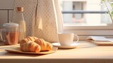 a delectable croissant and a cup of coffee elegantly placed on a kitchen countertop, the scene against a minimalist interior with modern furniture
