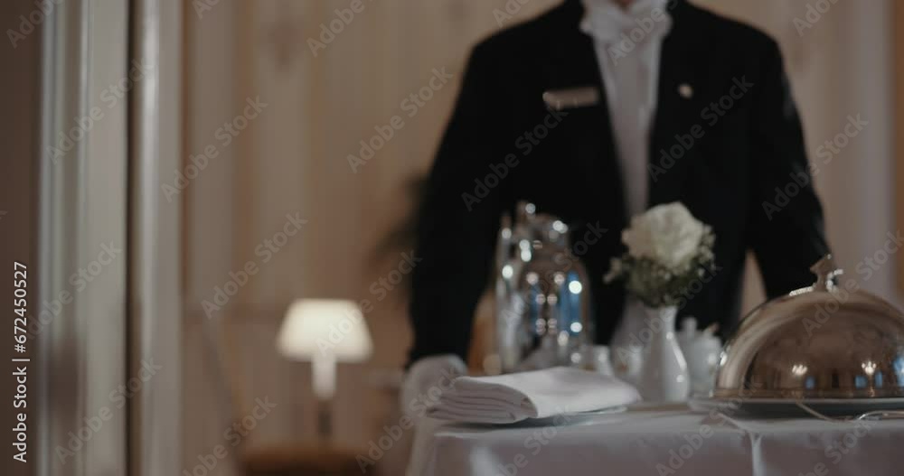 Man bringing a room service cart down the hall
