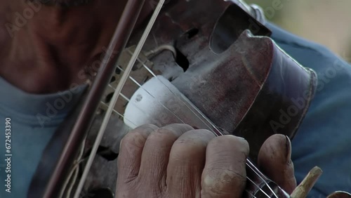 Hands of a Man Playing the Violin Outdoors in Chaco Province, Argentina. Close Up. photo