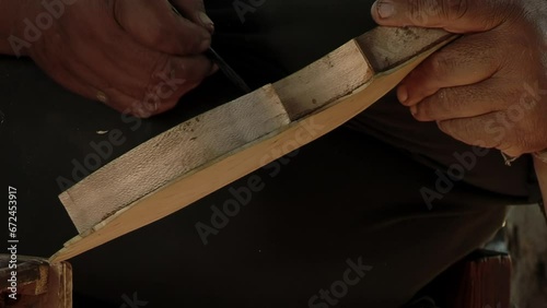 A Violin Maker Gluing Wood While Working at his Workshop in Chaco Province, Argentina. Close Up. photo