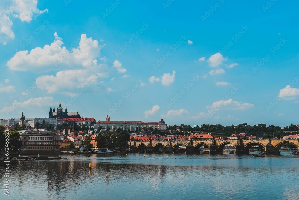 Scenic outdoor scene of a sparkling river with Charles bridge in the background in Prague