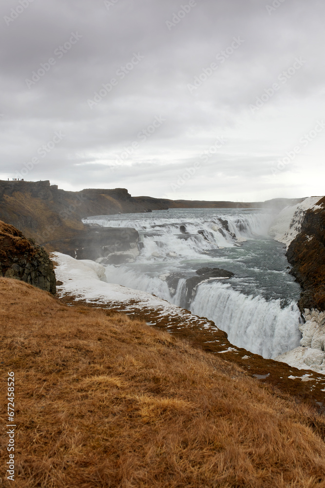Beautiful waterfall and mountains against cloudy sky Beautiful waterfall and mountains against cloudy sky