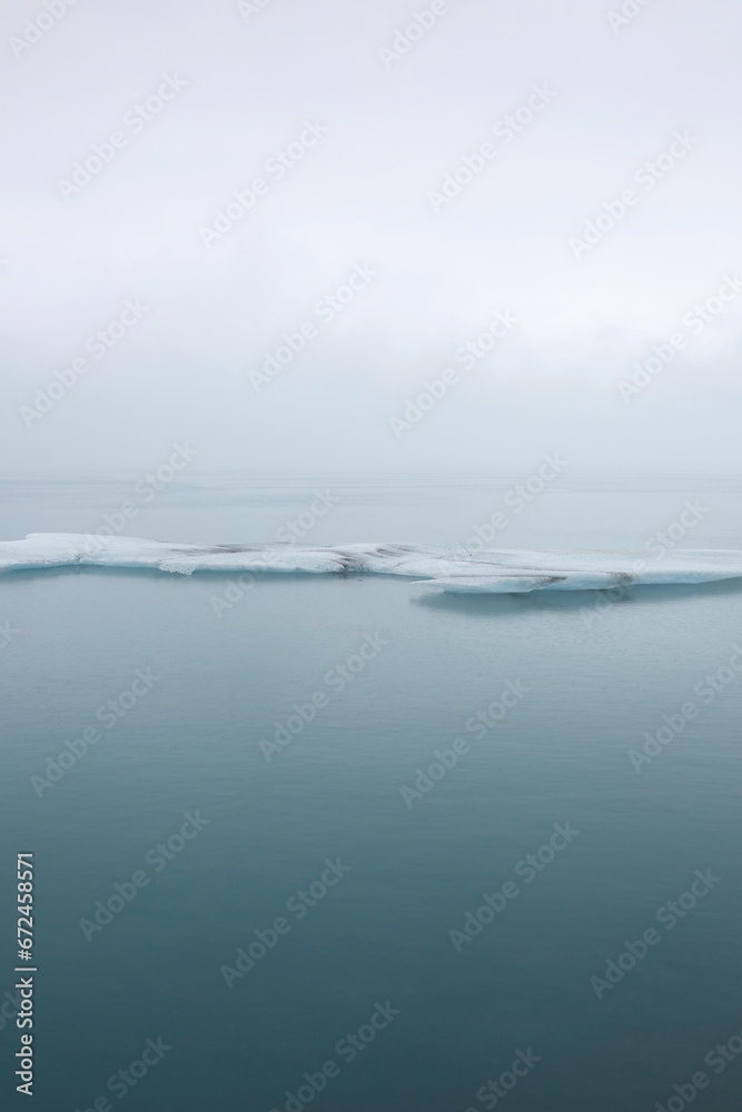 Ice formation in calm sea water against sky Ice formation in calm sea water against sky