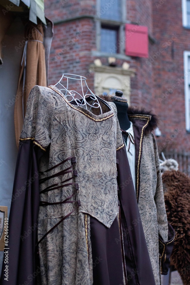 Array of medieval clothing hung up on a wall-mounted coat rack