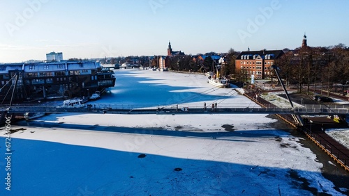 Scenic winter scene of a frozen river with houses along the banks