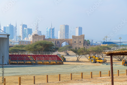 The skyline of modern Fujairah with a mosque among the modern architecture and a historic Arabic building in the forefront in Fujairah, United Arab Emirates. photo
